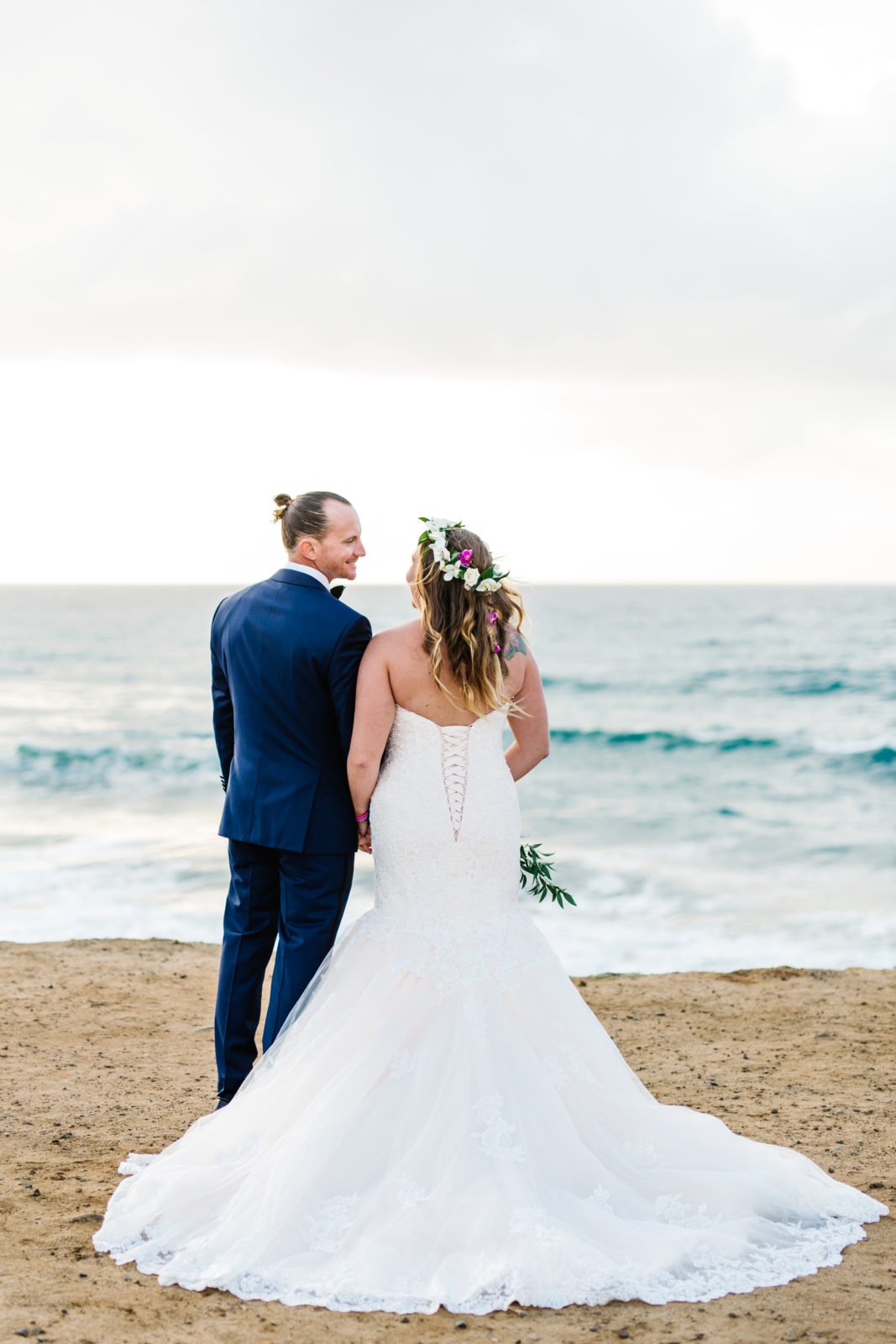 back of bride and groom by the ocean at sunset cliffs wedding