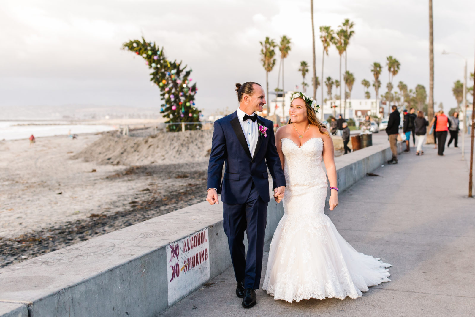 bride and groom walking by seawall at sunset cliffs wedding