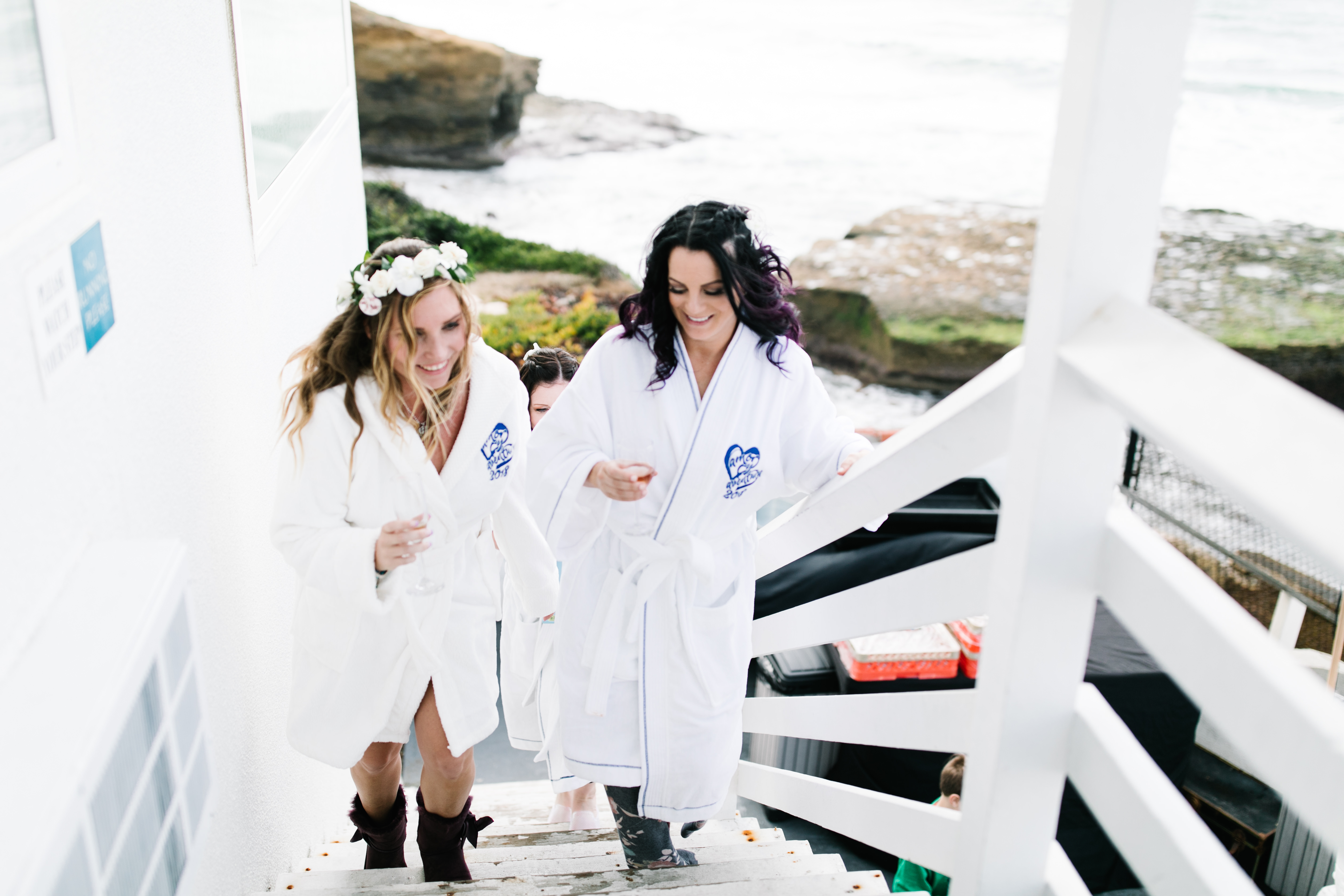 bride and bridesmaid walking up stairs with the ocean in the background sunset cliffs wedding