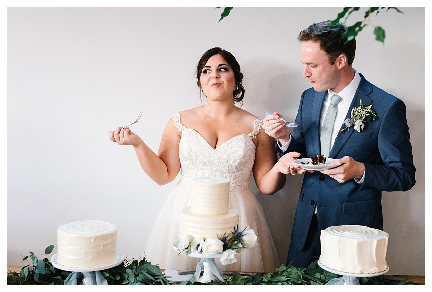 bride smiling with wedding cake in mouth