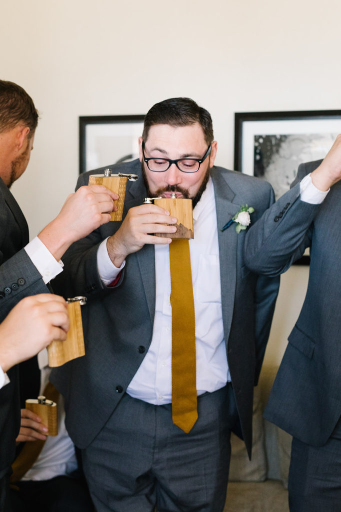 groomsmen drinking out of flasks