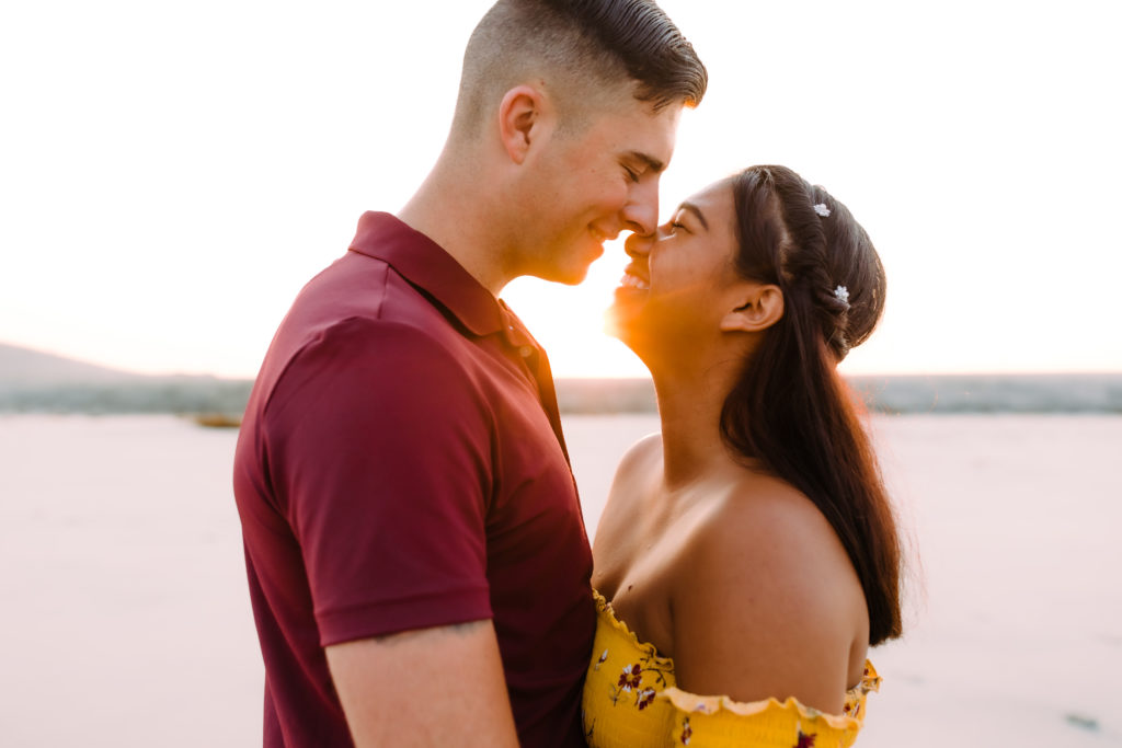 couple about to kiss with sun in background