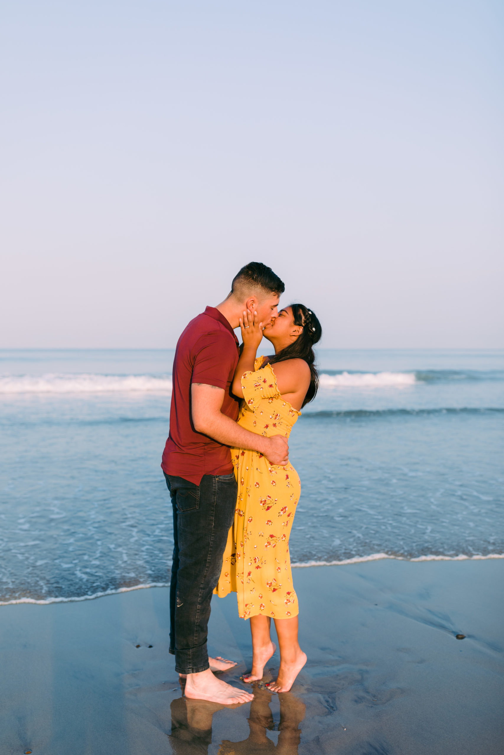 couple kissing during carlsbad beach engagement photos