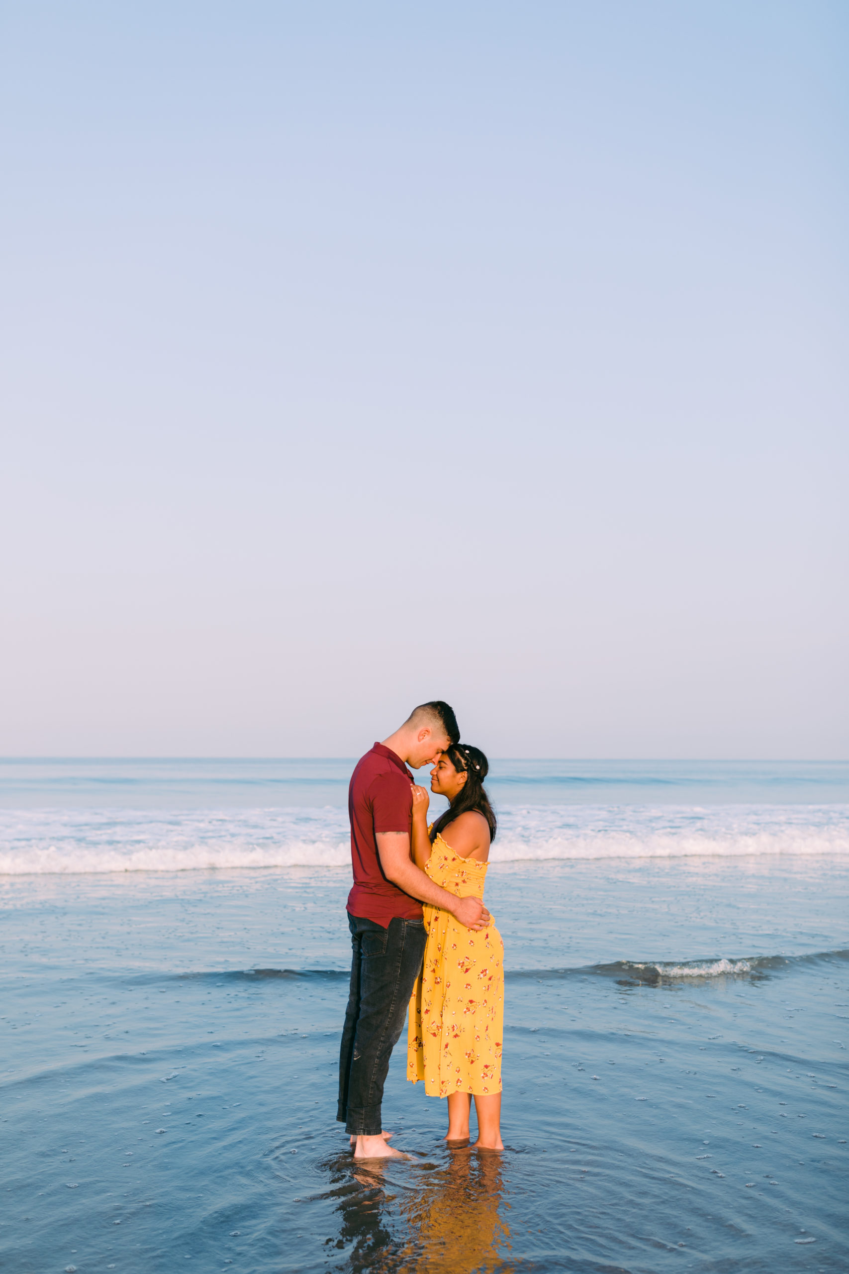 couple standing in ocean hugging